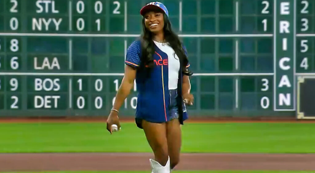 Simone Biles smiling with baseball in hand