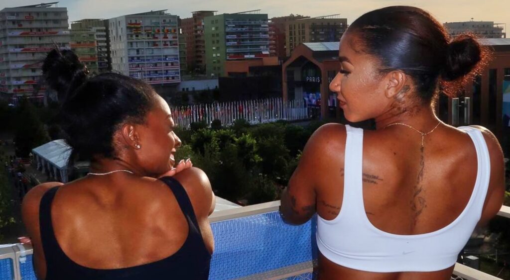 Simone Biles and Jordan Chiles posing on balcony