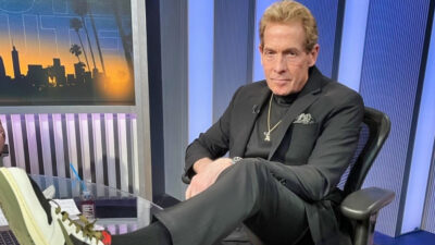 Skip Bayless with a foot on a desk