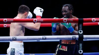 Terence Crawford smiles at Israel Madrimov during the tenth round