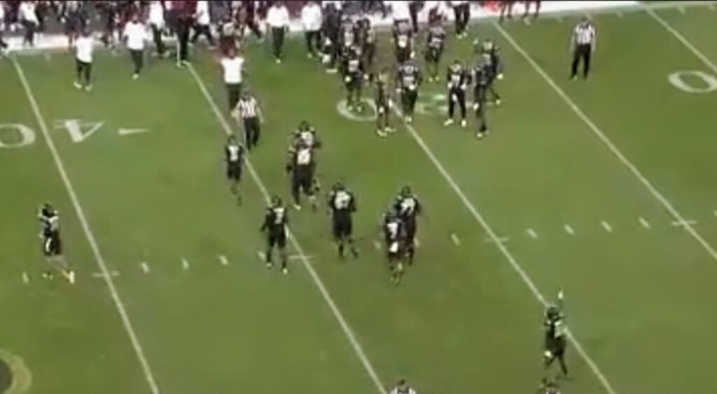 Shedeur Sanders and Colorado Buffaloes players running on field.