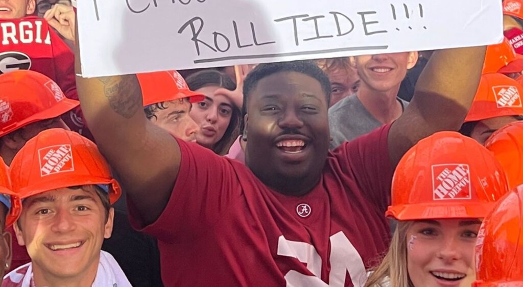 Alabama Crimson Tide fan holding up a sign.