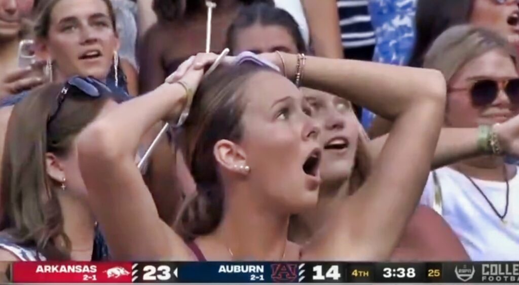 Auburn fan with her hands on her head.