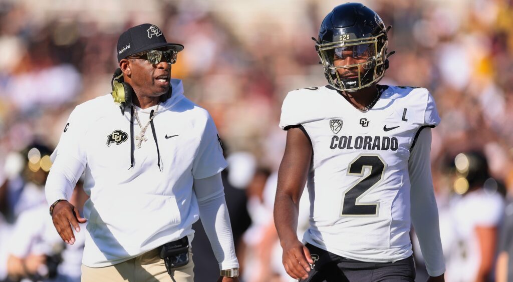 Deion Sanders and Shedeur Sanders talking during game.