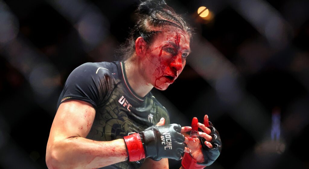 Irene Aldana fighting with blood coming down her face.