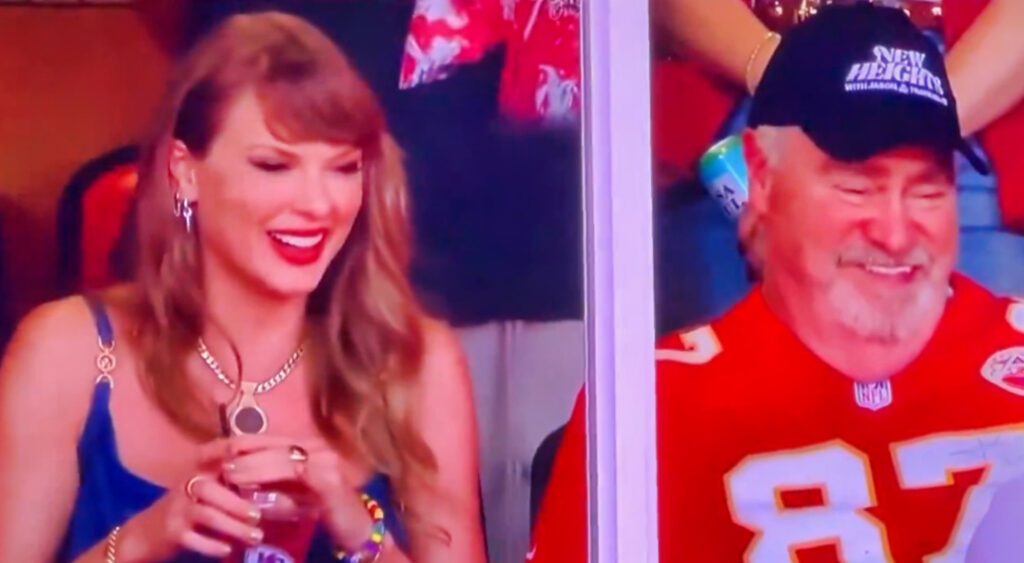 Taylor Swift sitting next to Ed Kelce