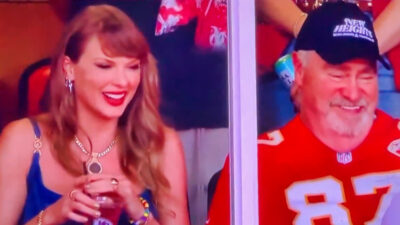 Taylor Swift sitting next to Ed Kelce