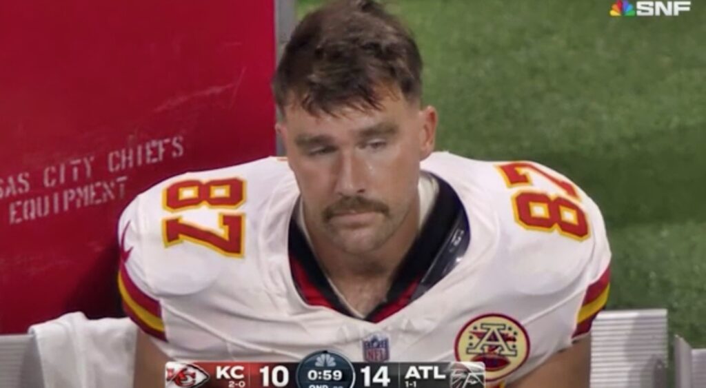 Travis Kelce looks on from the bench during a game.