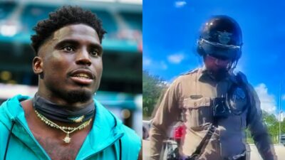 Tyreek Hill in warmups and a cop looking at him