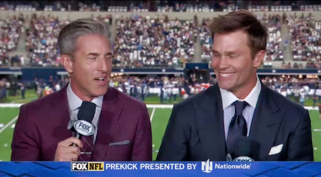 Kevin Burkhardt and Tom Brady speaking in the broadcast booth.