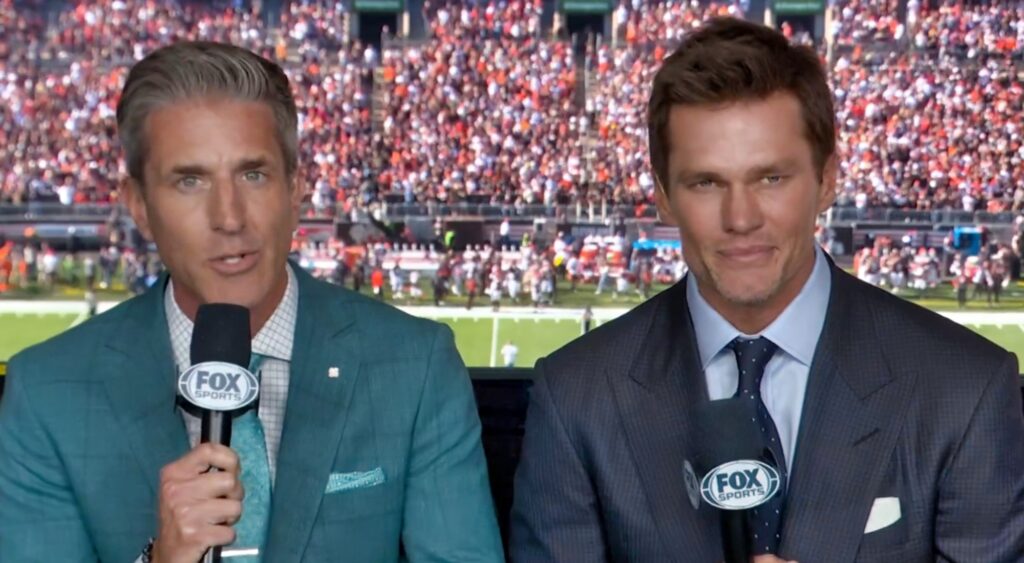 Kevin Burkhardt and Tom Brady speaking in broadcast booth.