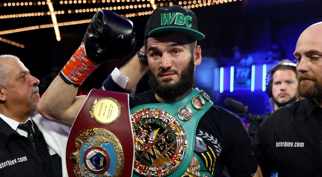 Artur Beterbiev holding hid belts