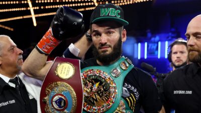 Artur Beterbiev holding hid belts