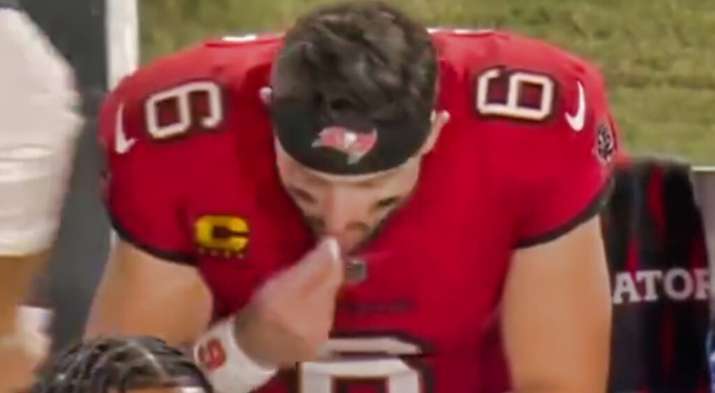 Baker Mayfield putting something into his mouth