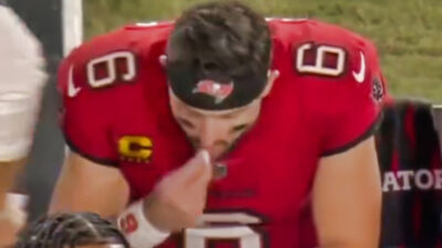 Baker Mayfield putting something into his mouth