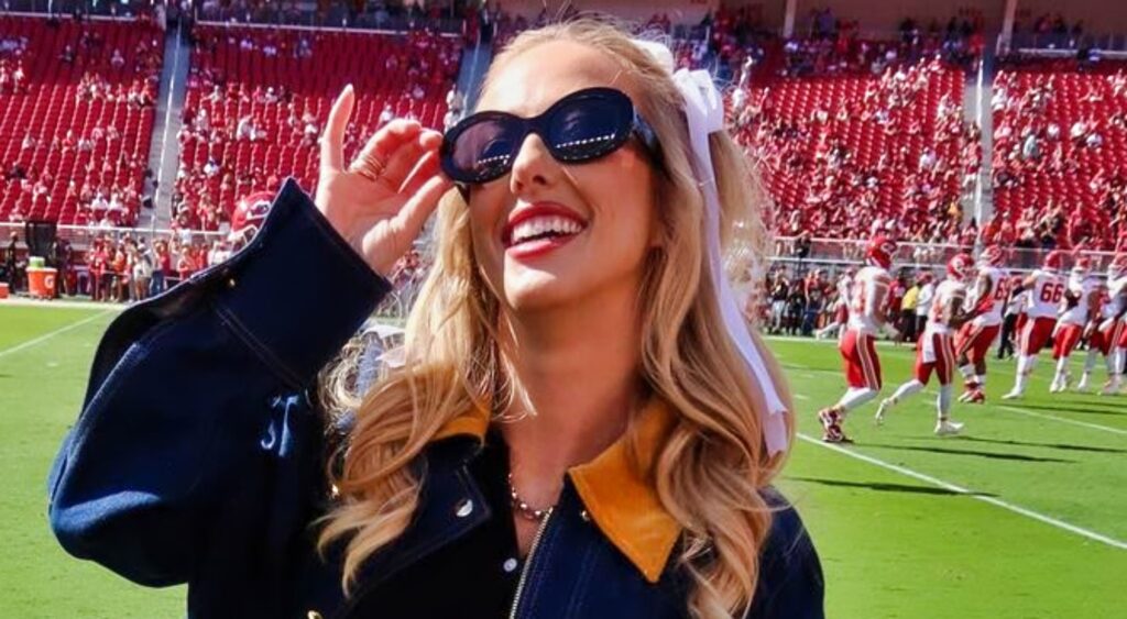 Brittany Mahomes posing for the camera on the field at Chiefs game.