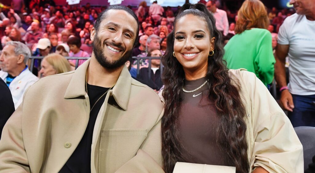 Colin Kaepernick and Nessa posing on sidelines