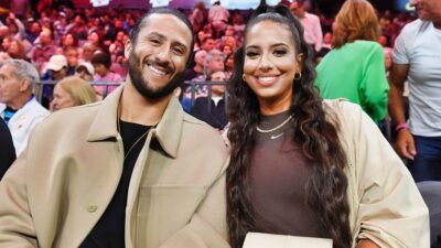 Colin Kaepernick and Nessa posing on sidelines