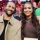 Colin Kaepernick and Nessa posing on sidelines