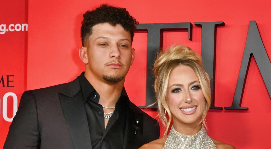 Patrick Mahomes and Brittany Mahomes looking on at event.