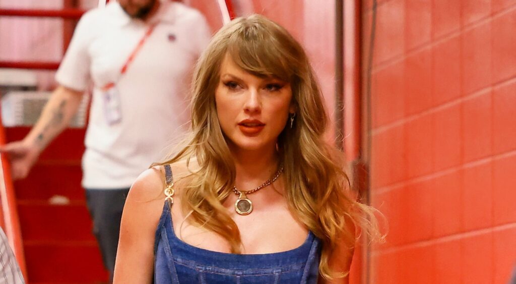 Taylor Swift looking on at event.