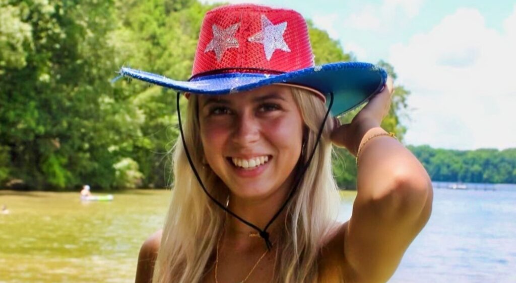 Haliey Welch in a cowboy hat by the lake.