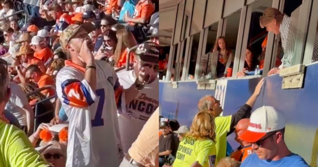 Denver Broncos fan speaking to Carolina Panthers' owners' box.