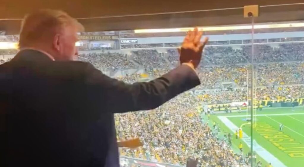 Donald Trump waving to fans at Steelers-Jets game.