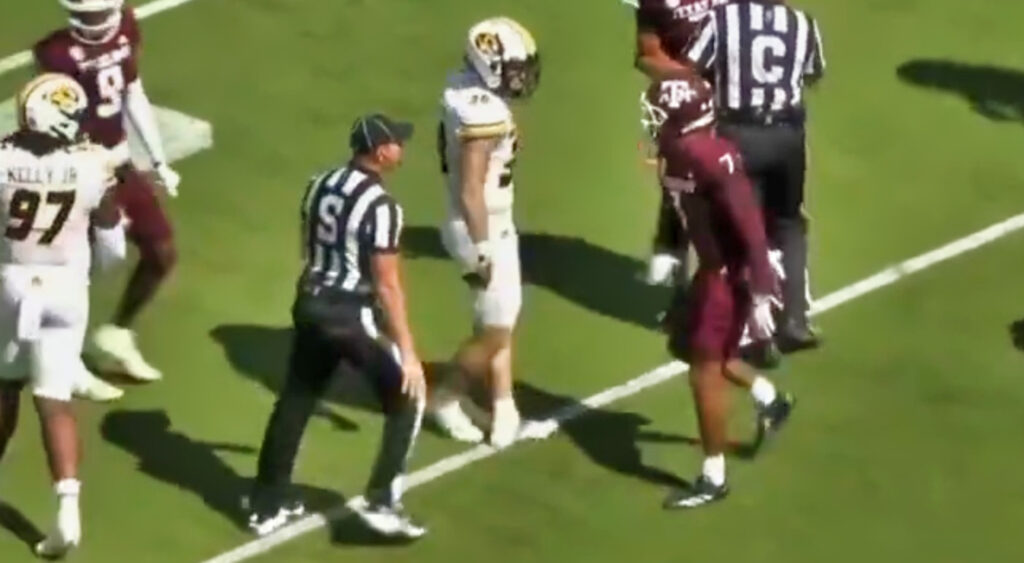 Referee getting between Texas A&M and Missouri players