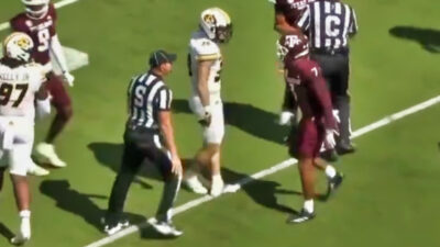 Referee getting between Texas A&M and Missouri players