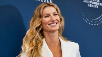 Gisele Bundchen smiling and posing in white outfit