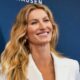 Gisele Bundchen smiling and posing in white outfit