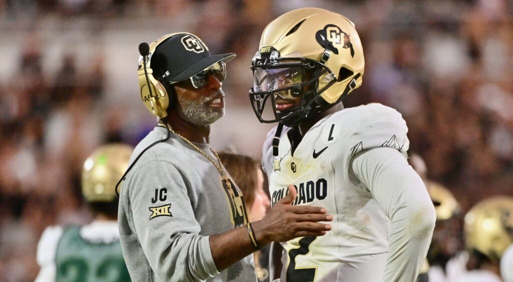 Deion and Shedeur Sanders talking during game.