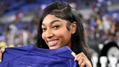 Angel Reese holding up ravens jersey