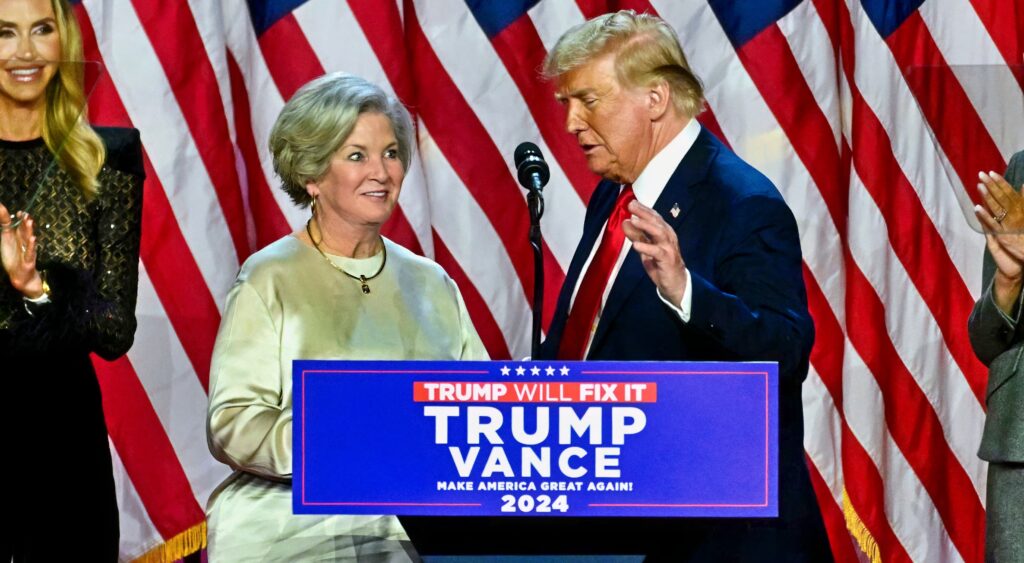 Susie Wiles and Donald Trump at podium