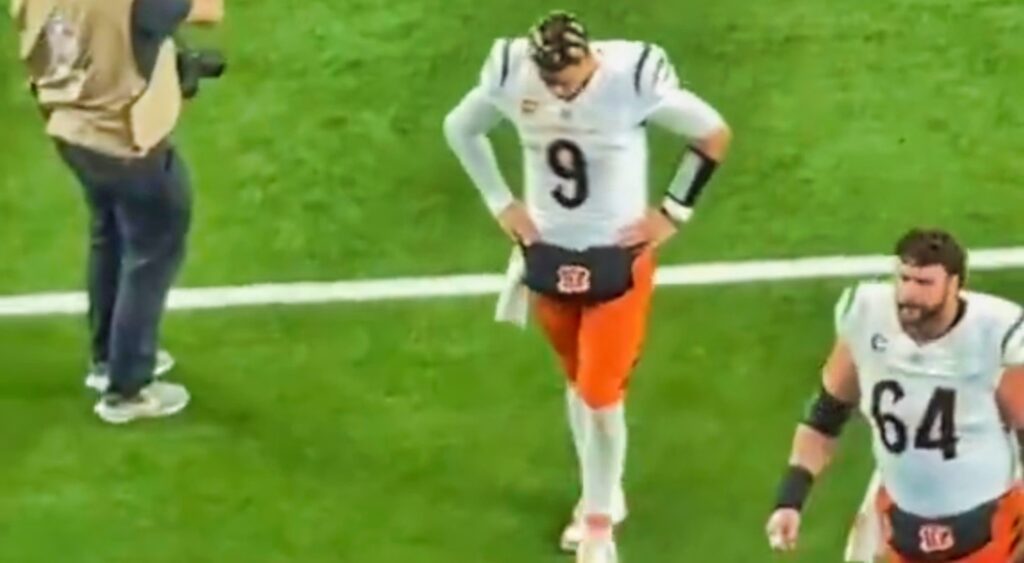 Joe Burrow walking off the field with his head down.