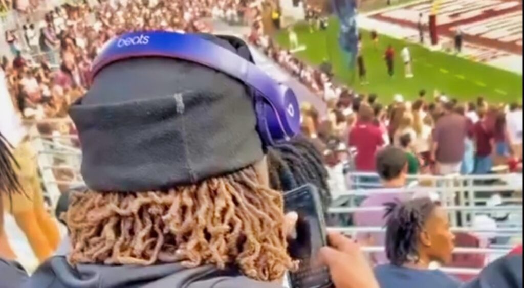 Mississippi State Bulldogs recruit on his phone in the stands