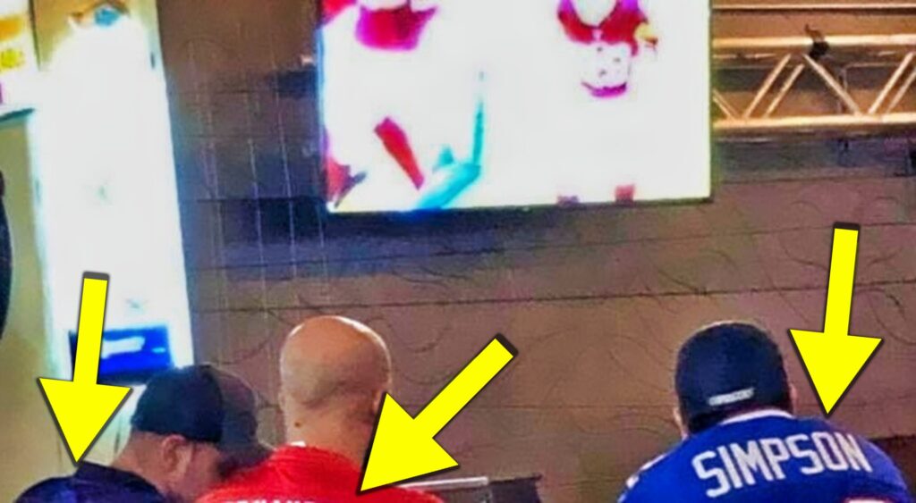 NFL fans watching the game at a bar.