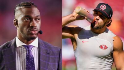 Nick Bosa drinking from water bottle and Robert Griffin in suit