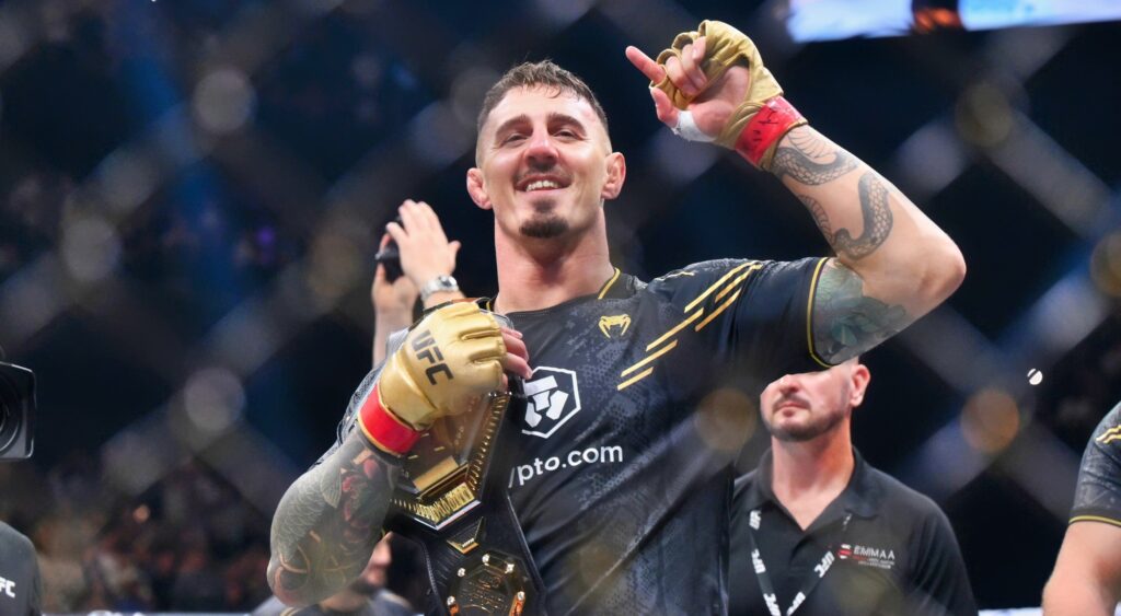 Tom Aspinall of England raises the interim UFC heavyweight championship belt after his knockout victory against Curtis Blaydes of the U.S. during the UFC 304