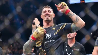 Tom Aspinall of England raises the interim UFC heavyweight championship belt after his knockout victory against Curtis Blaydes of the U.S. during the UFC 304