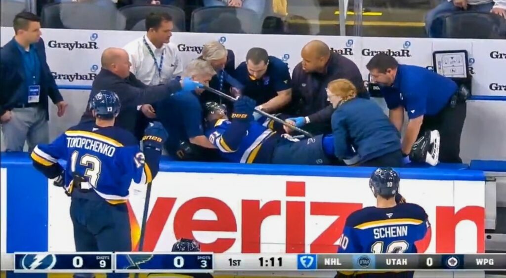 Dylan Holloway of St. Louis Blues being helped on bench.