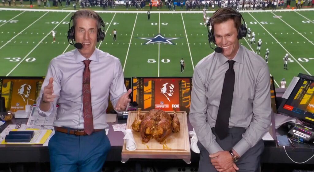 Kevin Burkhardt and Tom Brady in broadcast booth.