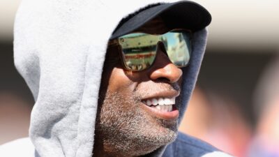 Deion Sanders in hoodie and sunglasses