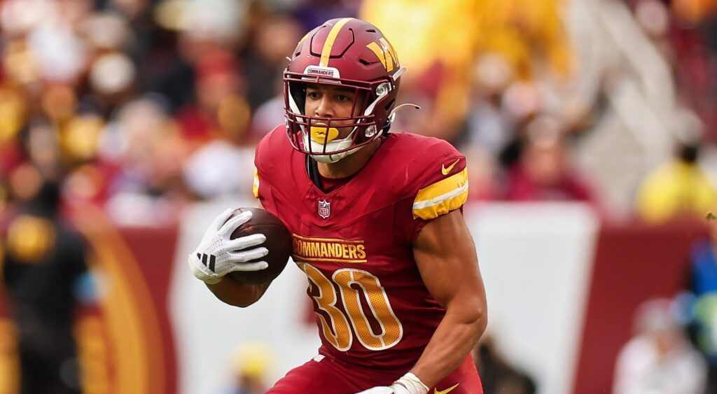 Austin Ekeler of Washington Commanders running with football.