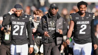 Deion Sanders, Shedeur Sanders, and Shilo Sanders walking on field