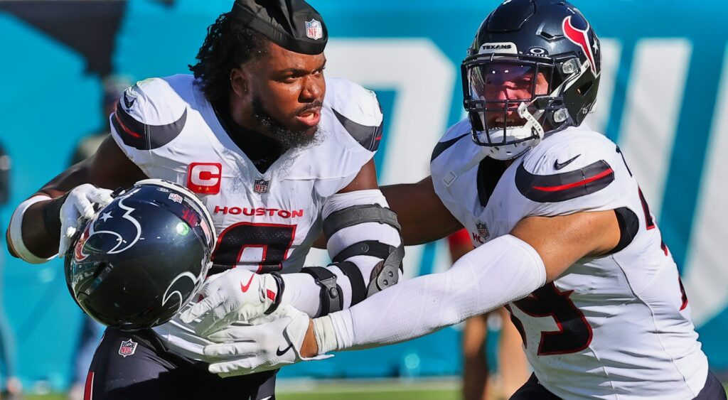 Azeez Al-Shaair in uniform being held back by teammate