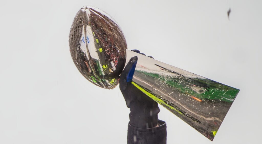 Lombardi Trophy being held in air. Blll Romanowski revealed he had 20 concussions in his career.