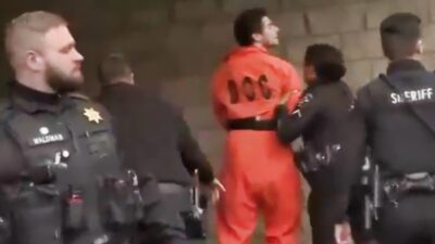 Luigi Mangione in orange jumpsuit and handcuffs