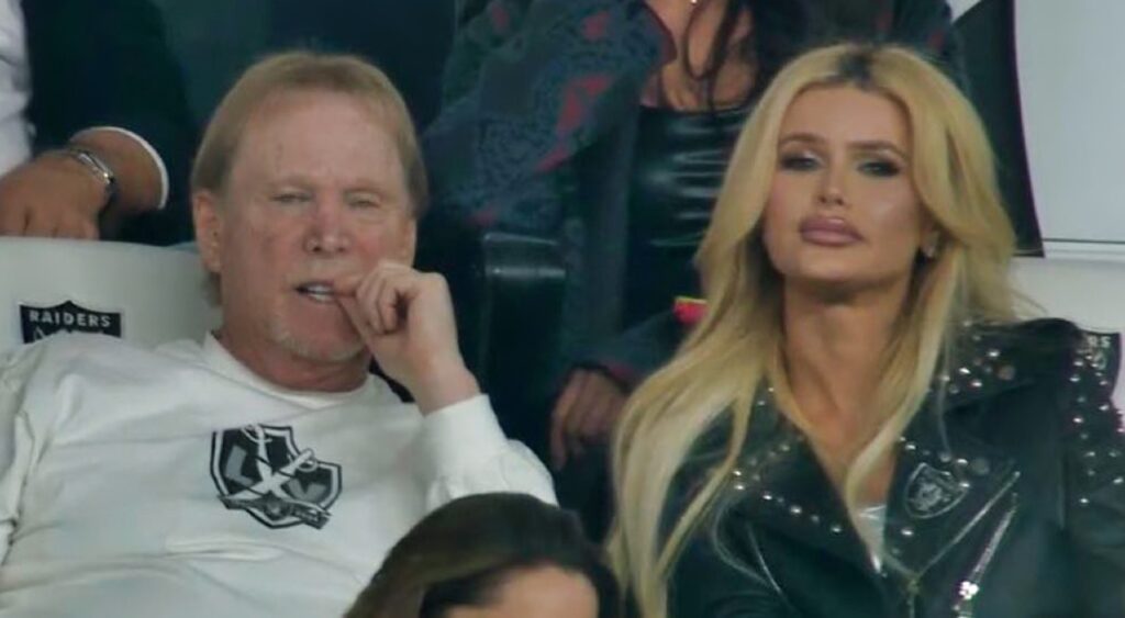 Mark Davis and blonde female in the stands watching the game.